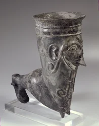 Bucchero vaas in de vorm van een been met gebeeldhouwd gezicht, Etruskische periode, 2e helft van de 6e eeuw v.Chr.